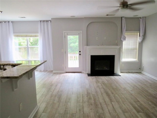 58 Torero Trl, Newnan, GA 30263 - unfurnished living room featuring baseboards, light wood-type flooring, healthy amount of natural light, and a ceiling fan