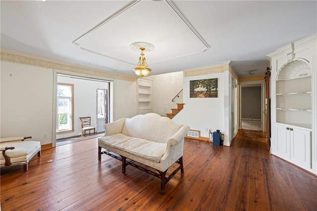 interior space featuring built in shelves, visible vents, dark wood-type flooring, ornamental molding, and baseboards