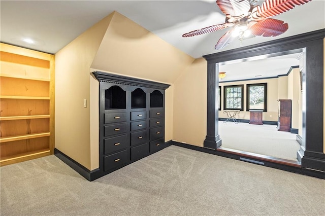 unfurnished bedroom featuring carpet, decorative columns, baseboards, and a ceiling fan