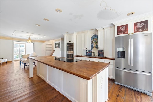 kitchen with dark wood-style floors, butcher block countertops, a center island, stainless steel appliances, and a sink