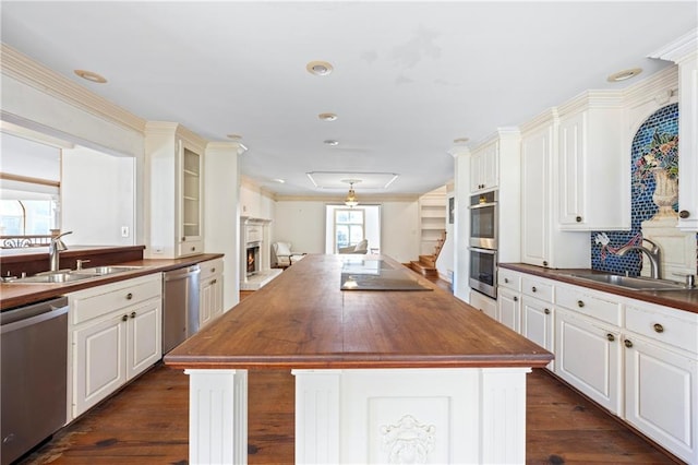 kitchen featuring wood counters, a kitchen island, stainless steel appliances, and a sink