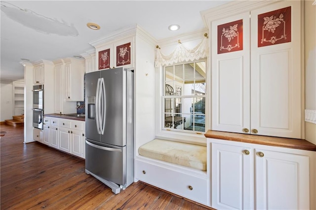 kitchen featuring dark wood-style flooring, dark countertops, appliances with stainless steel finishes, glass insert cabinets, and white cabinetry