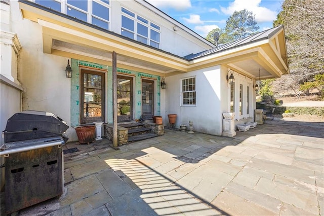 rear view of property with a patio area and stucco siding