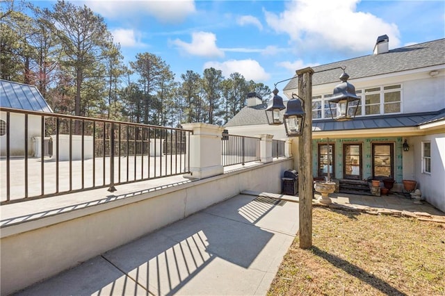 view of patio featuring a porch, a grill, and a balcony