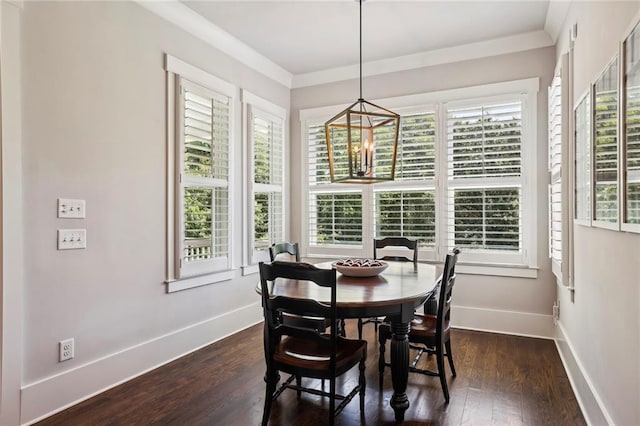 dining area with a notable chandelier, crown molding, baseboards, and dark wood-type flooring