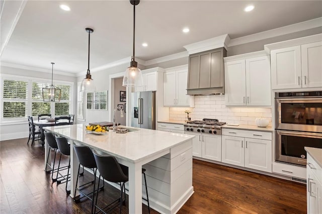 kitchen featuring crown molding, stainless steel appliances, a sink, decorative backsplash, and custom range hood