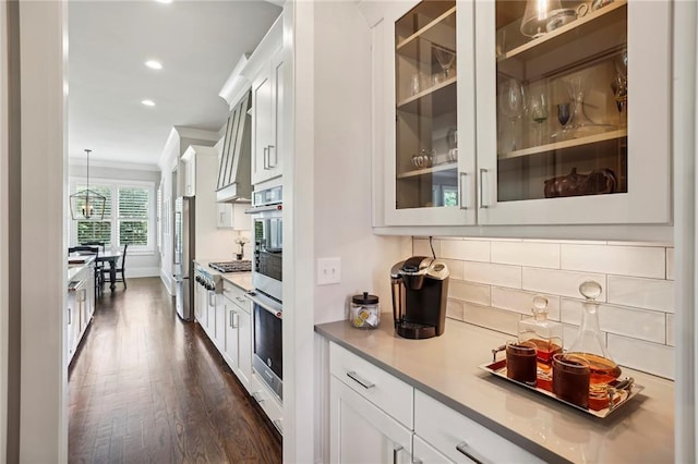 kitchen featuring ornamental molding, white cabinetry, glass insert cabinets, and tasteful backsplash