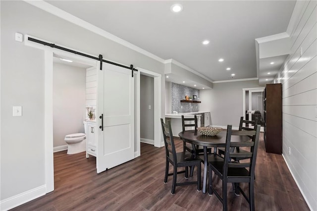 dining space with a barn door, baseboards, dark wood-type flooring, crown molding, and recessed lighting