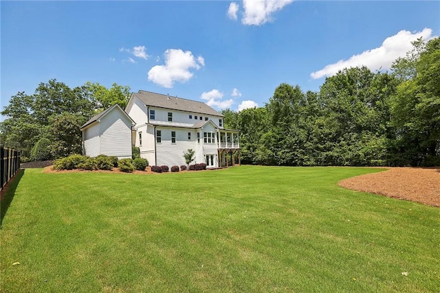 back of property with fence and a lawn