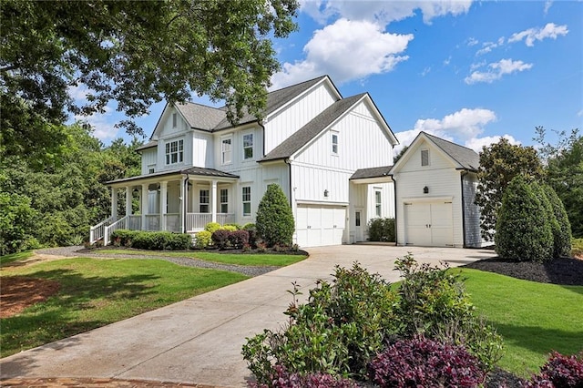 modern inspired farmhouse with covered porch, driveway, a front lawn, and board and batten siding