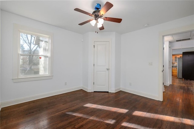 spare room featuring ceiling fan and dark wood-type flooring