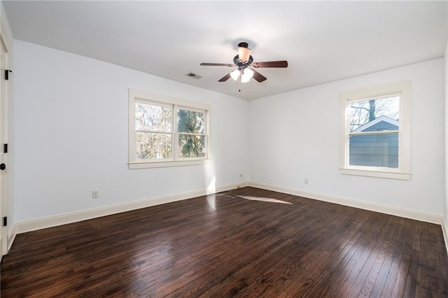 spare room with dark hardwood / wood-style floors, ceiling fan, and plenty of natural light