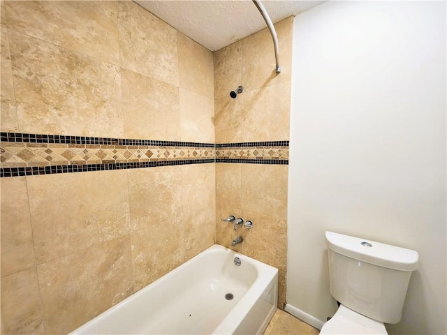 bathroom with tiled shower / bath combo, toilet, a textured ceiling, and tile patterned flooring