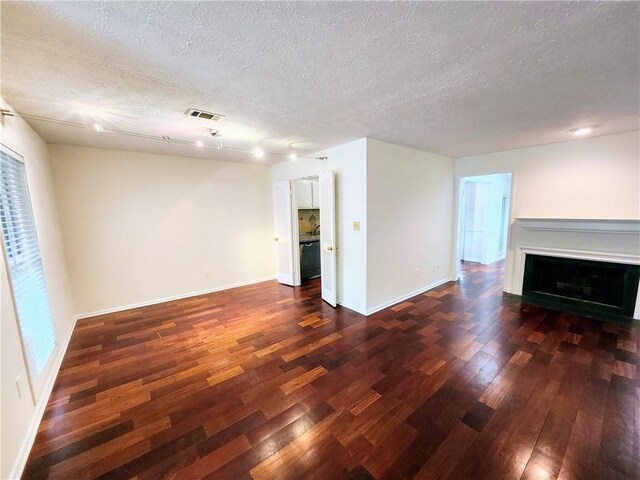 unfurnished living room featuring hardwood / wood-style floors and a textured ceiling