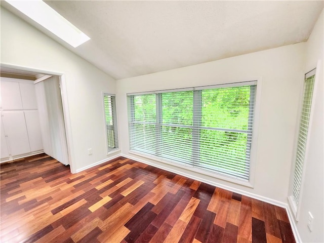 unfurnished room with lofted ceiling with skylight and wood-type flooring