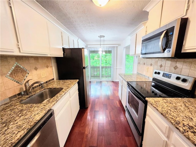 kitchen featuring appliances with stainless steel finishes, dark wood-type flooring, backsplash, and white cabinetry