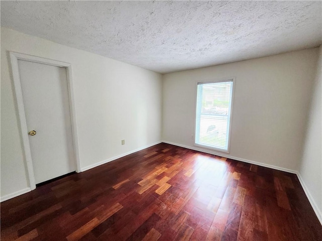 empty room featuring wood-type flooring and a textured ceiling