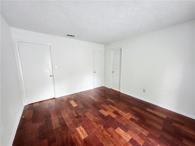 empty room with a textured ceiling and hardwood / wood-style floors