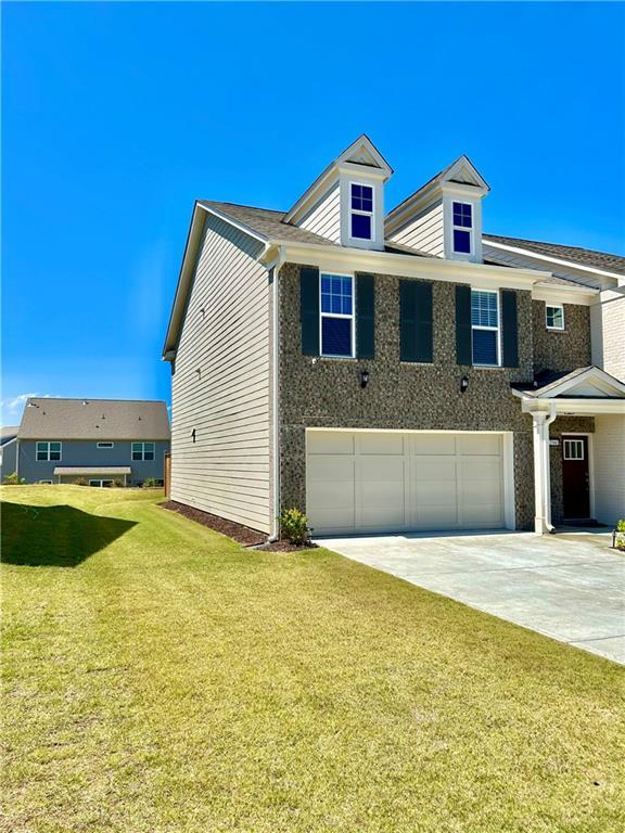 view of side of home with a garage, driveway, and a lawn