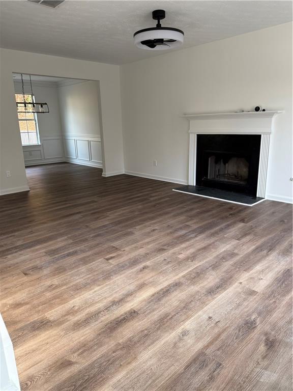 unfurnished living room featuring hardwood / wood-style floors and ceiling fan