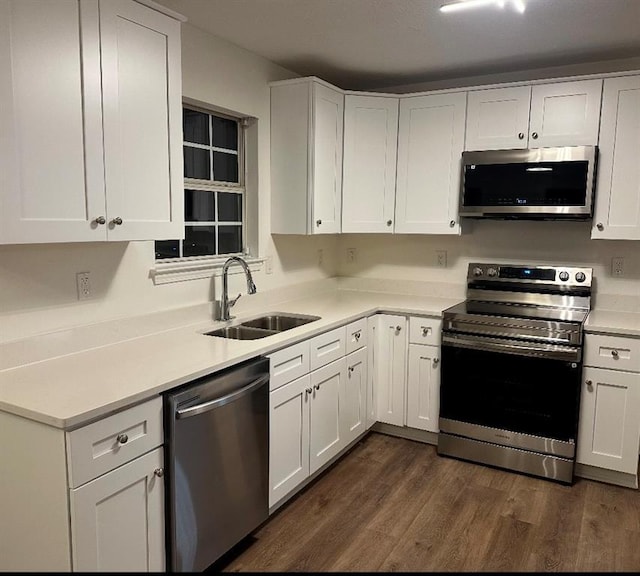 kitchen featuring white cabinets, stainless steel appliances, dark wood-type flooring, and sink