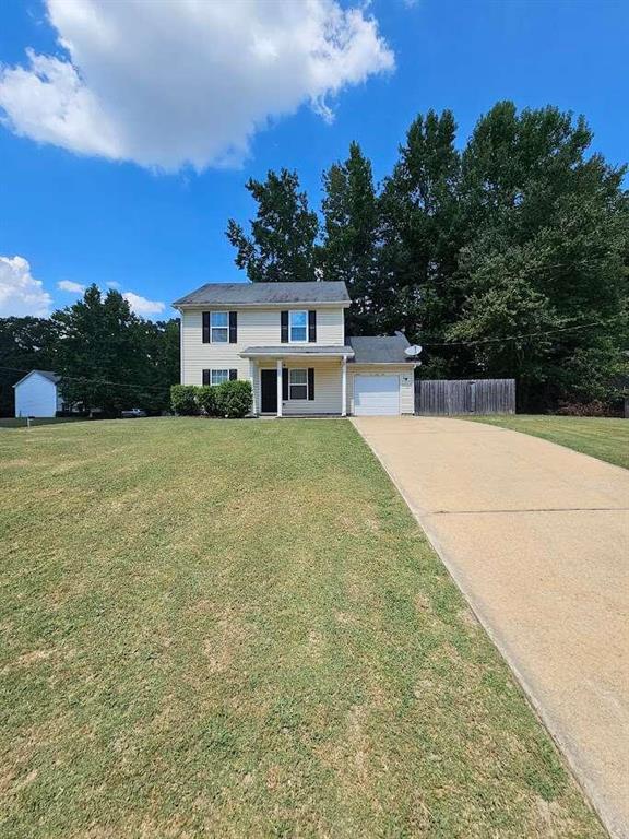 view of front of house featuring a front lawn and a garage