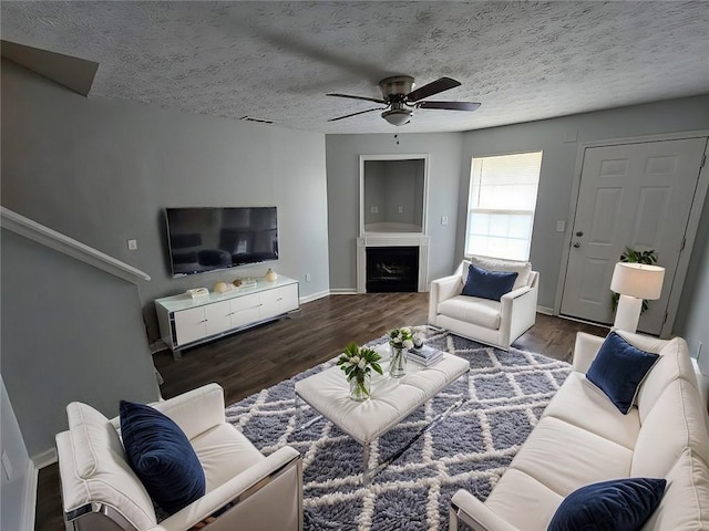 living room with visible vents, a textured ceiling, wood finished floors, and a fireplace