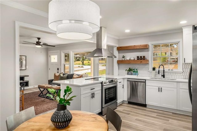 1282 Westridge Rd SW, Atlanta, GA 30311 - kitchen with a peninsula, island exhaust hood, a sink, appliances with stainless steel finishes, and crown molding