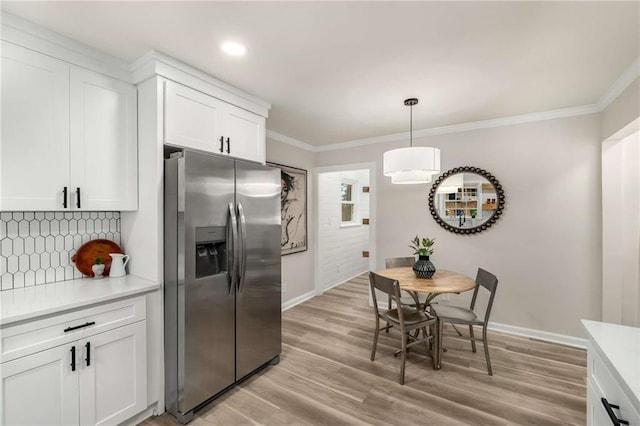 1282 Westridge Rd SW, Atlanta, GA 30311 - kitchen with decorative backsplash, stainless steel fridge, light countertops, and crown molding