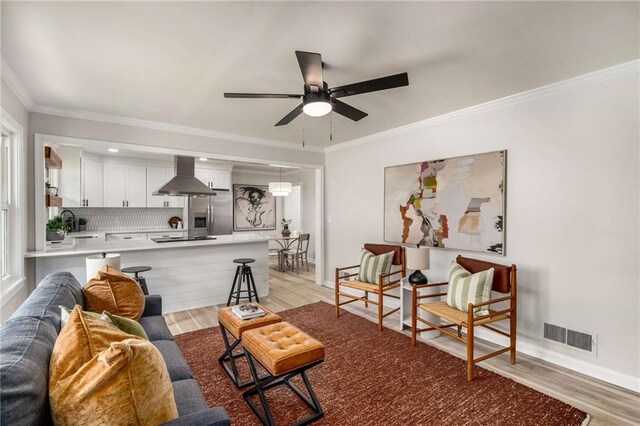 1282 Westridge Rd SW, Atlanta, GA 30311 - living room featuring visible vents, light wood-style flooring, crown molding, and a ceiling fan