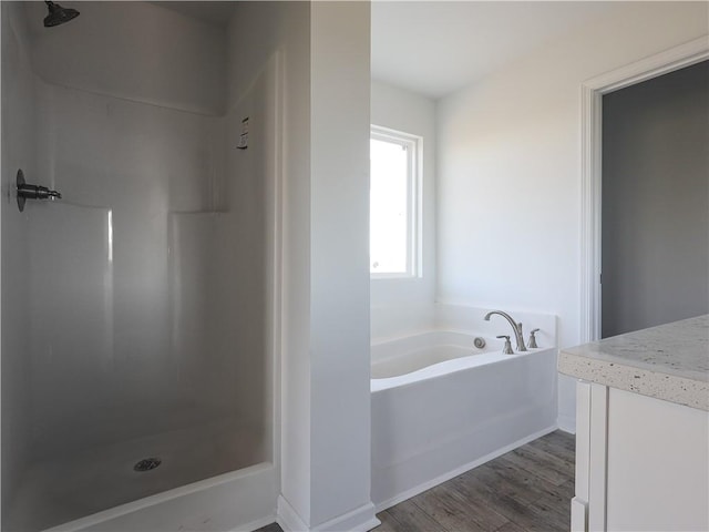 bathroom with hardwood / wood-style flooring and separate shower and tub