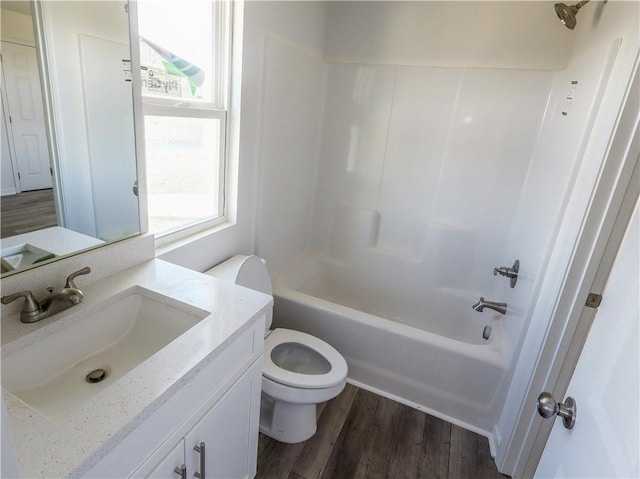 full bathroom featuring vanity, hardwood / wood-style flooring, tub / shower combination, and toilet