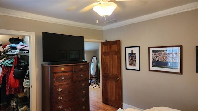 1171 Goodwin Rd NE, Atlanta, GA 30324 - bedroom with a spacious closet, ornamental molding, light wood finished floors, a closet, and a ceiling fan