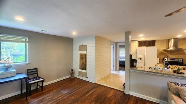 1171 Goodwin Rd NE, Atlanta, GA 30324 - kitchen with wall chimney exhaust hood, white refrigerator with ice dispenser, electric range, wood finished floors, and light stone counters