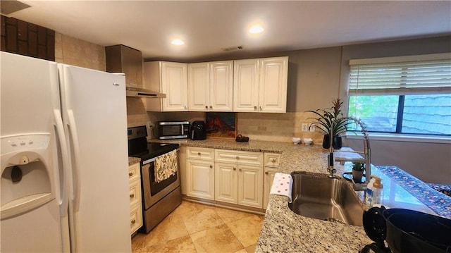 1171 Goodwin Rd NE, Atlanta, GA 30324 - kitchen with stainless steel appliances, wall chimney exhaust hood, white cabinets, light stone counters, and recessed lighting
