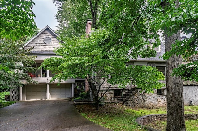 1171 Goodwin Rd NE, Atlanta, GA 30324 - view of property hidden behind natural elements with an attached garage, stairs, concrete driveway, and a chimney