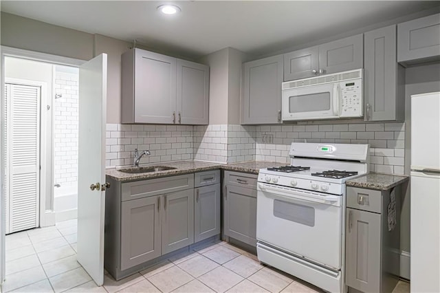 1171 Goodwin Rd NE, Atlanta, GA 30324 - kitchen with white appliances, gray cabinets, light tile patterned floors, light stone countertops, and recessed lighting