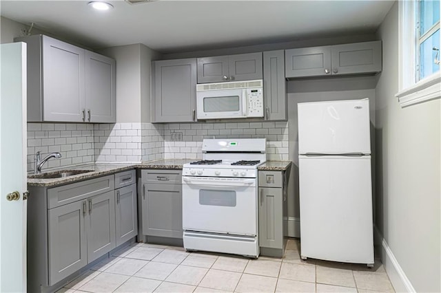 1171 Goodwin Rd NE, Atlanta, GA 30324 - kitchen with white appliances, gray cabinets, decorative backsplash, light tile patterned floors, and light stone countertops