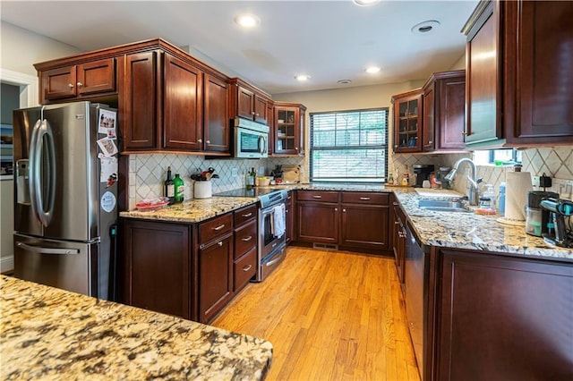 1171 Goodwin Rd NE, Atlanta, GA 30324 - kitchen with appliances with stainless steel finishes, light wood-style flooring, tasteful backsplash, glass insert cabinets, and recessed lighting