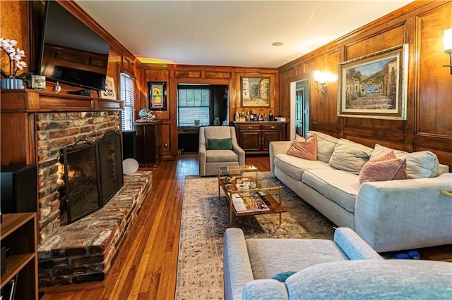 1171 Goodwin Rd NE, Atlanta, GA 30324 - living room featuring dark wood finished floors, a fireplace, crown molding, and wooden walls