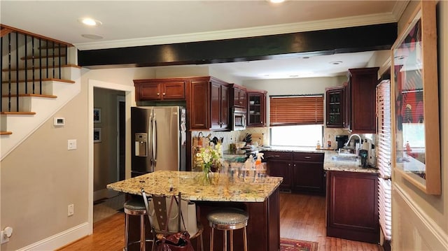 1171 Goodwin Rd NE, Atlanta, GA 30324 - kitchen with appliances with stainless steel finishes, crown molding, wood finished floors, glass insert cabinets, and light stone countertops