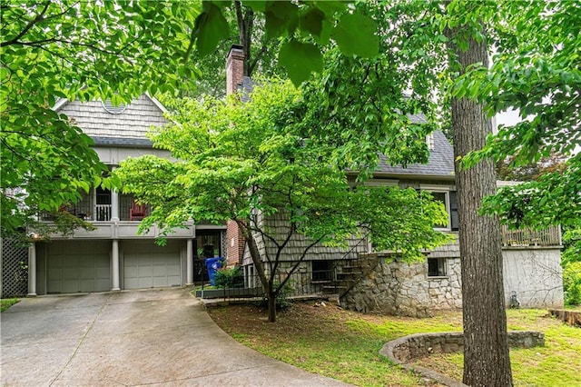 1171 Goodwin Rd NE, Atlanta, GA 30324 - obstructed view of property with concrete driveway, an attached garage, a chimney, and a balcony
