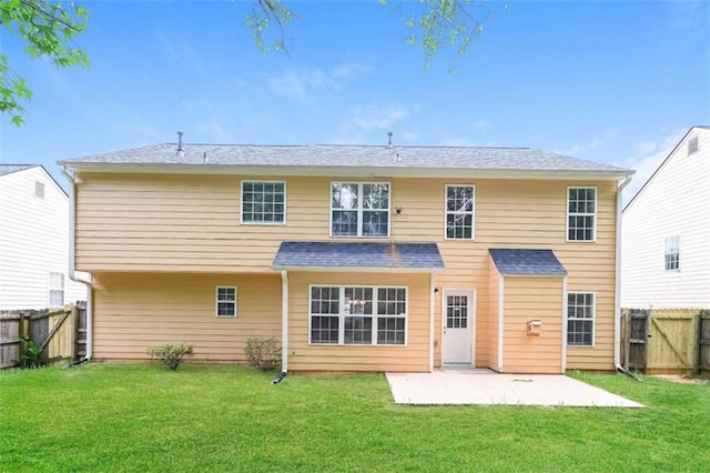 back of house with a patio area and a lawn