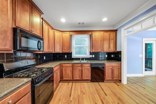 kitchen featuring black appliances, light hardwood / wood-style floors, and tasteful backsplash