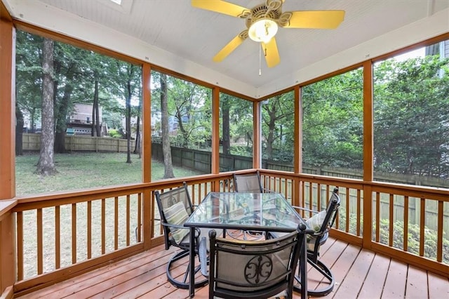 sunroom featuring ceiling fan, a skylight, and plenty of natural light