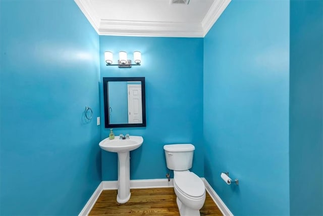 bathroom with toilet, ornamental molding, and hardwood / wood-style floors