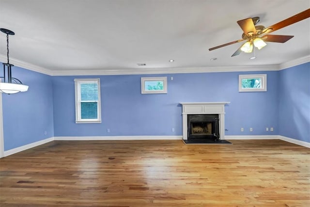 unfurnished living room with crown molding, light wood-type flooring, and a wealth of natural light