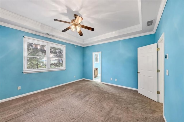 carpeted spare room featuring ornamental molding, a tray ceiling, and ceiling fan