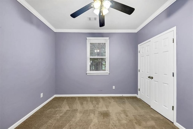 unfurnished bedroom with carpet, crown molding, and ceiling fan