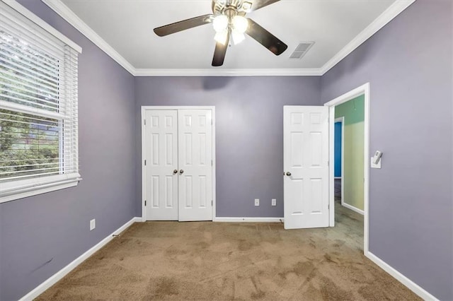 unfurnished bedroom with a closet, ornamental molding, light colored carpet, and ceiling fan